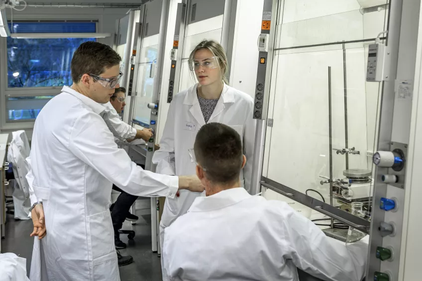 Three students in a lab. Photo. 